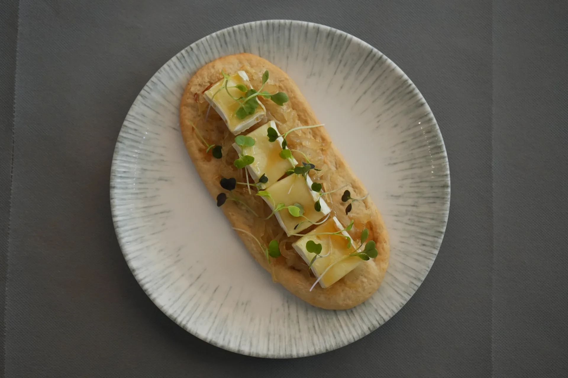 Coca con Cebolla Caramelizada, Queso Brie y Rayadura de Foie, de El Redolí, en la Jornada de Cocas de Dénia