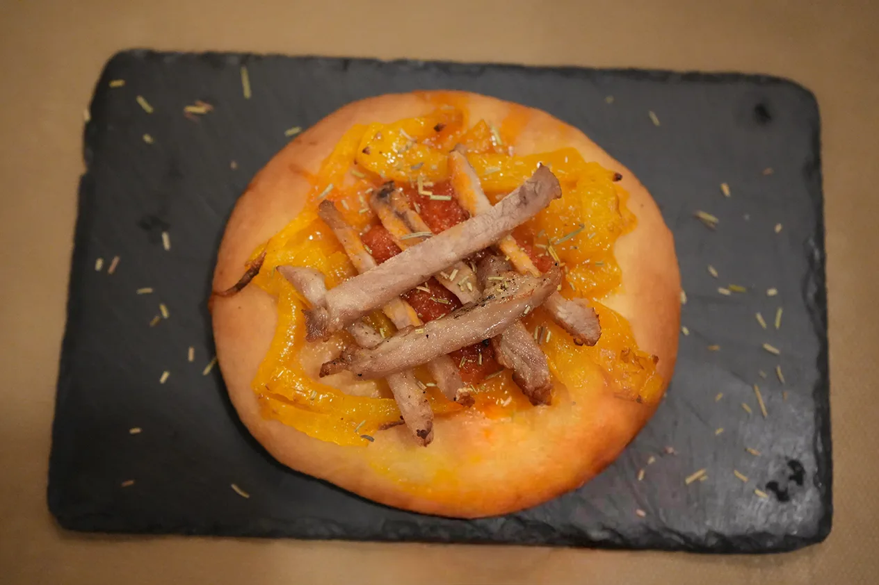Coca de Secreto de Cerdo, Sobrasada, Cebolla Caramelizada y Miel de Romero, de El Secreto de Loreto, en la Jornada de Cocas de Dénia